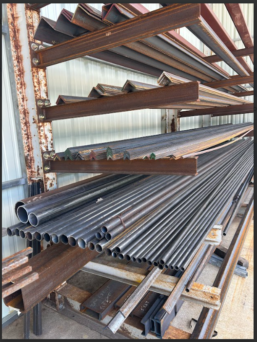 Stack of gray metal pipes outdoors.