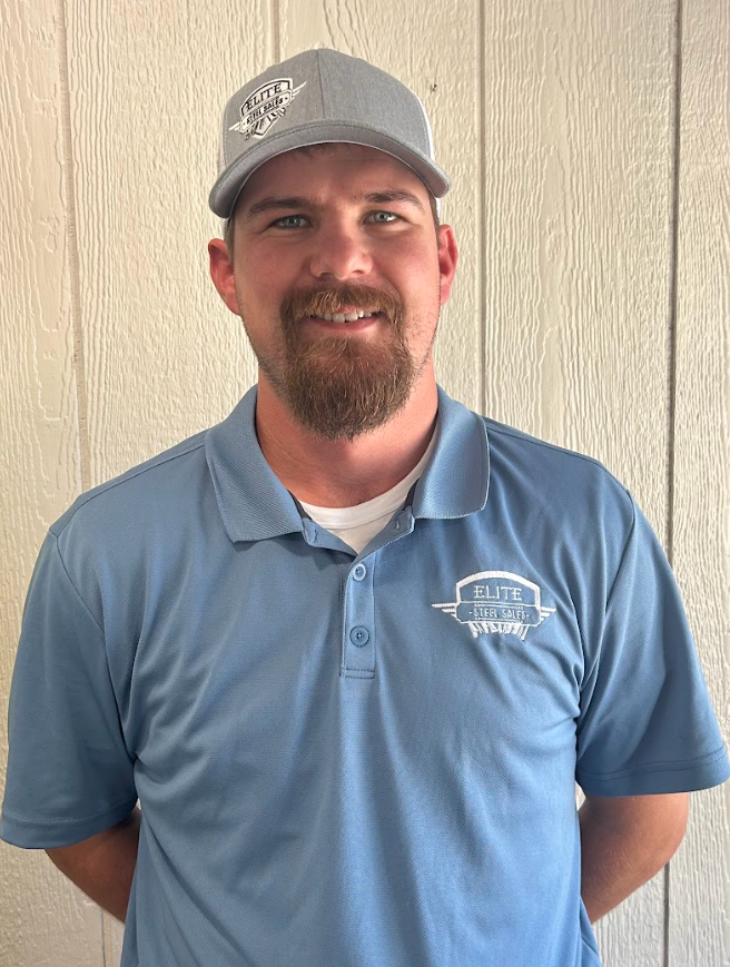 Man wearing a blue polo shirt and gray hat with logo, smiling.