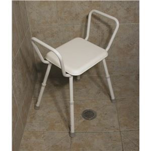 A white stool is sitting on a tiled floor in a shower.