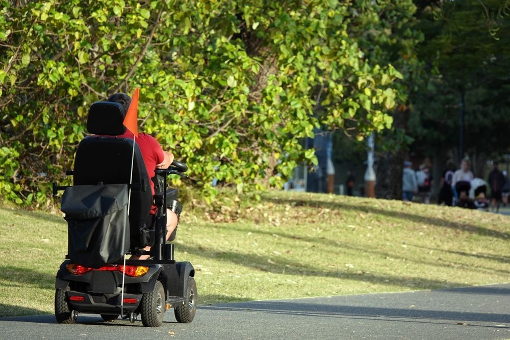 Person On Mobility Scooter Traveling In Park