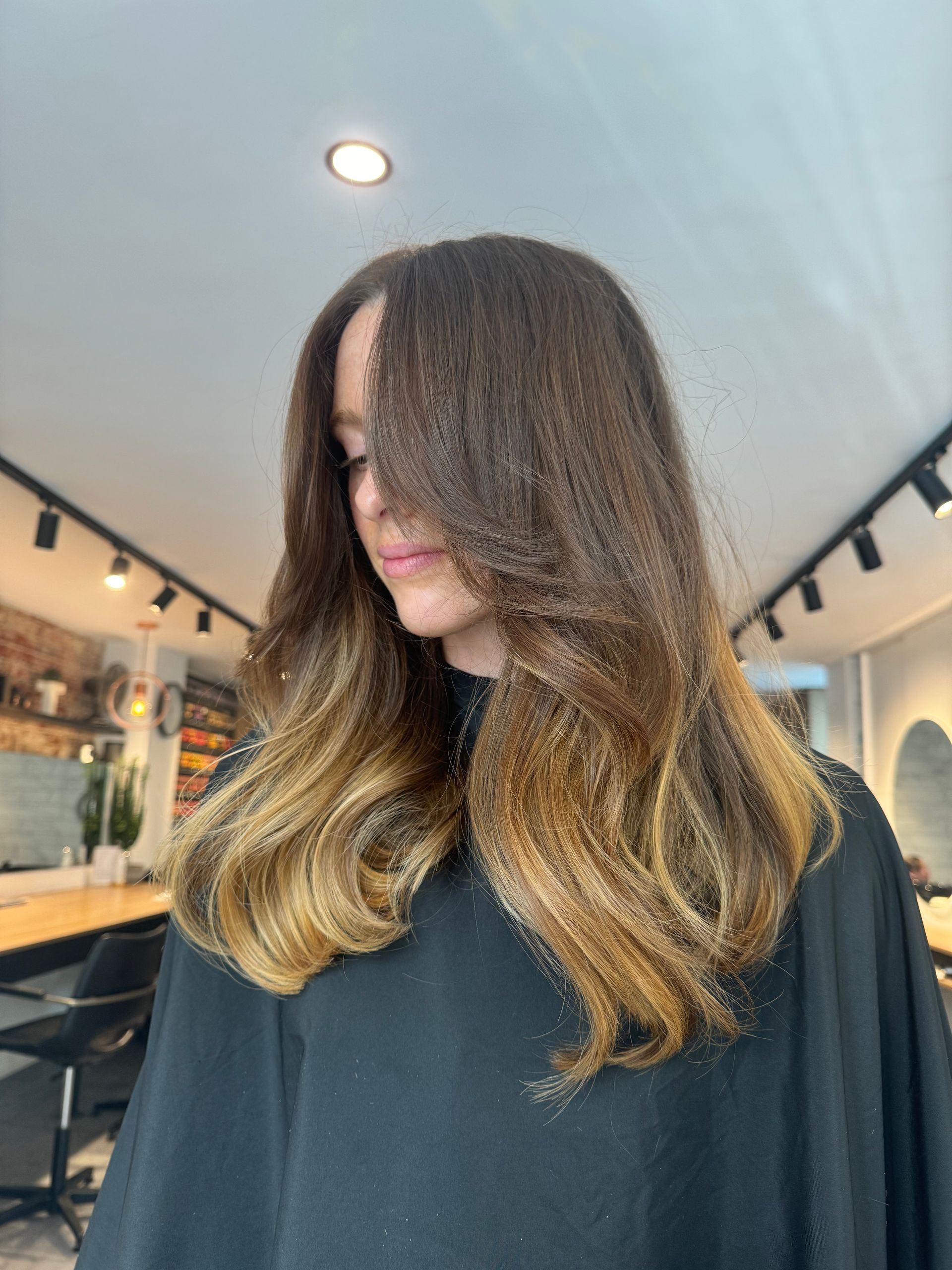 A woman is covering her face with her hair in Samson & Delilah Subiaco.