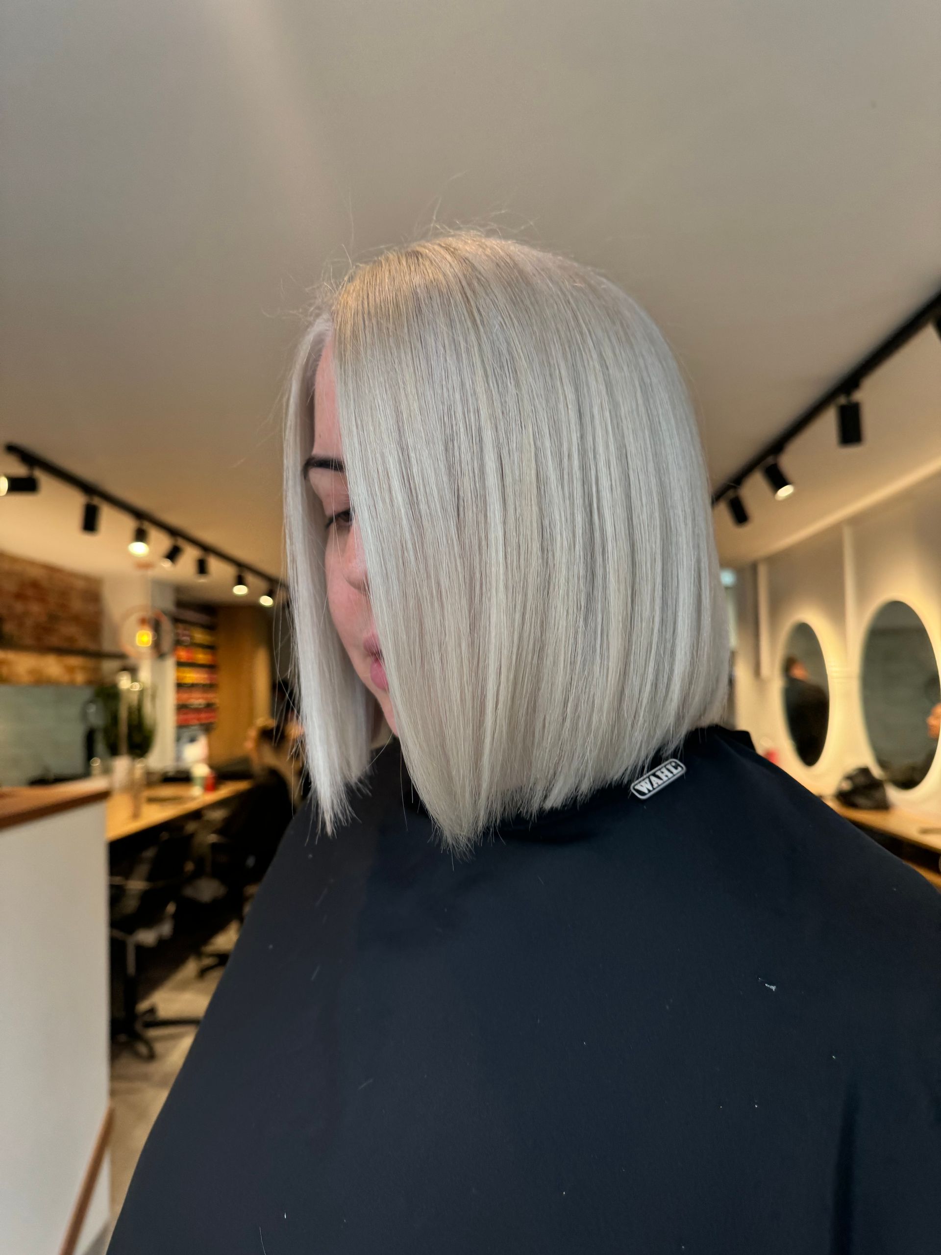 A woman with blonde hair is wearing a black cape in Samson & Delilah Subiaco.