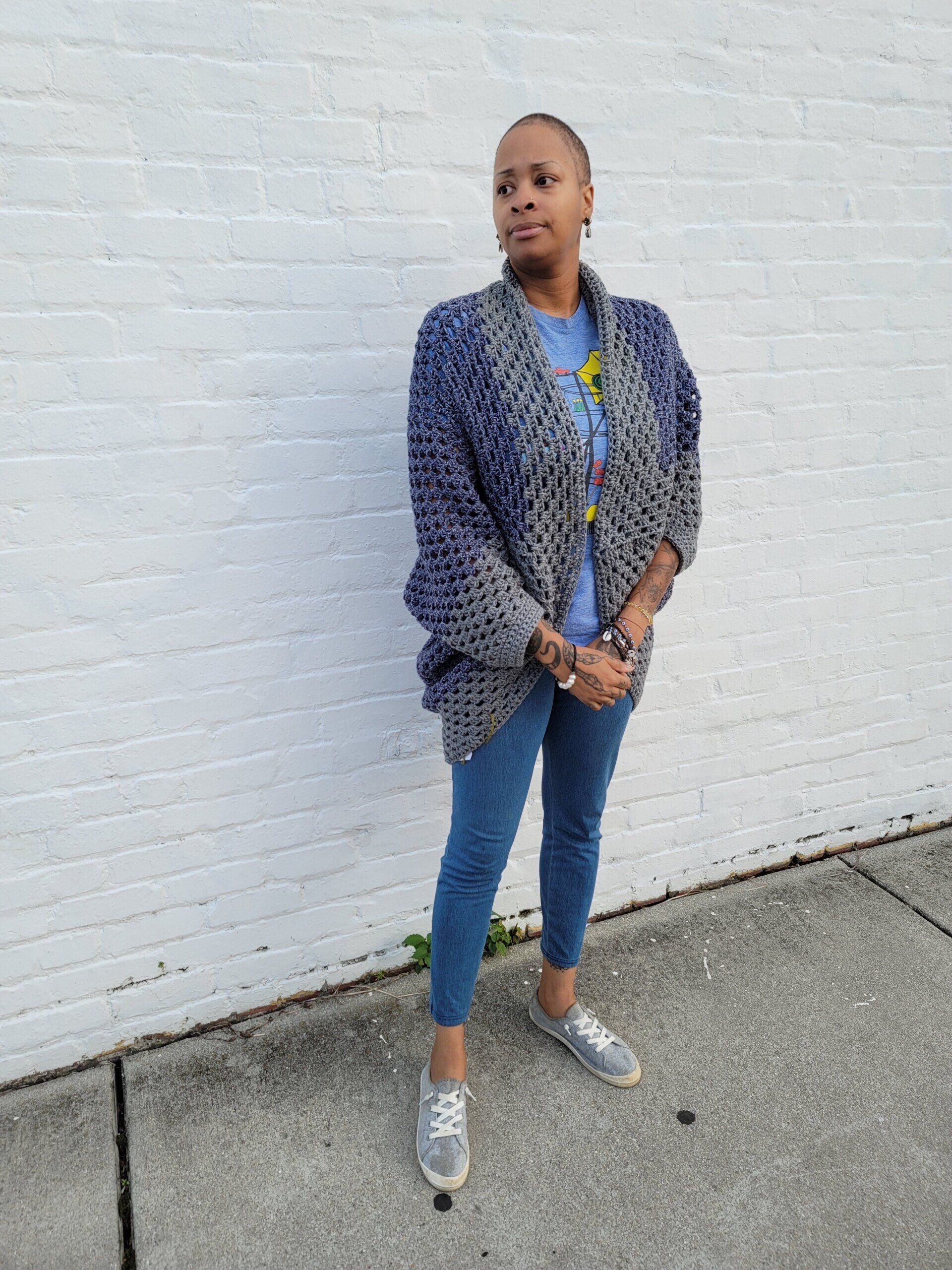 A woman is standing in front of a white brick wall.