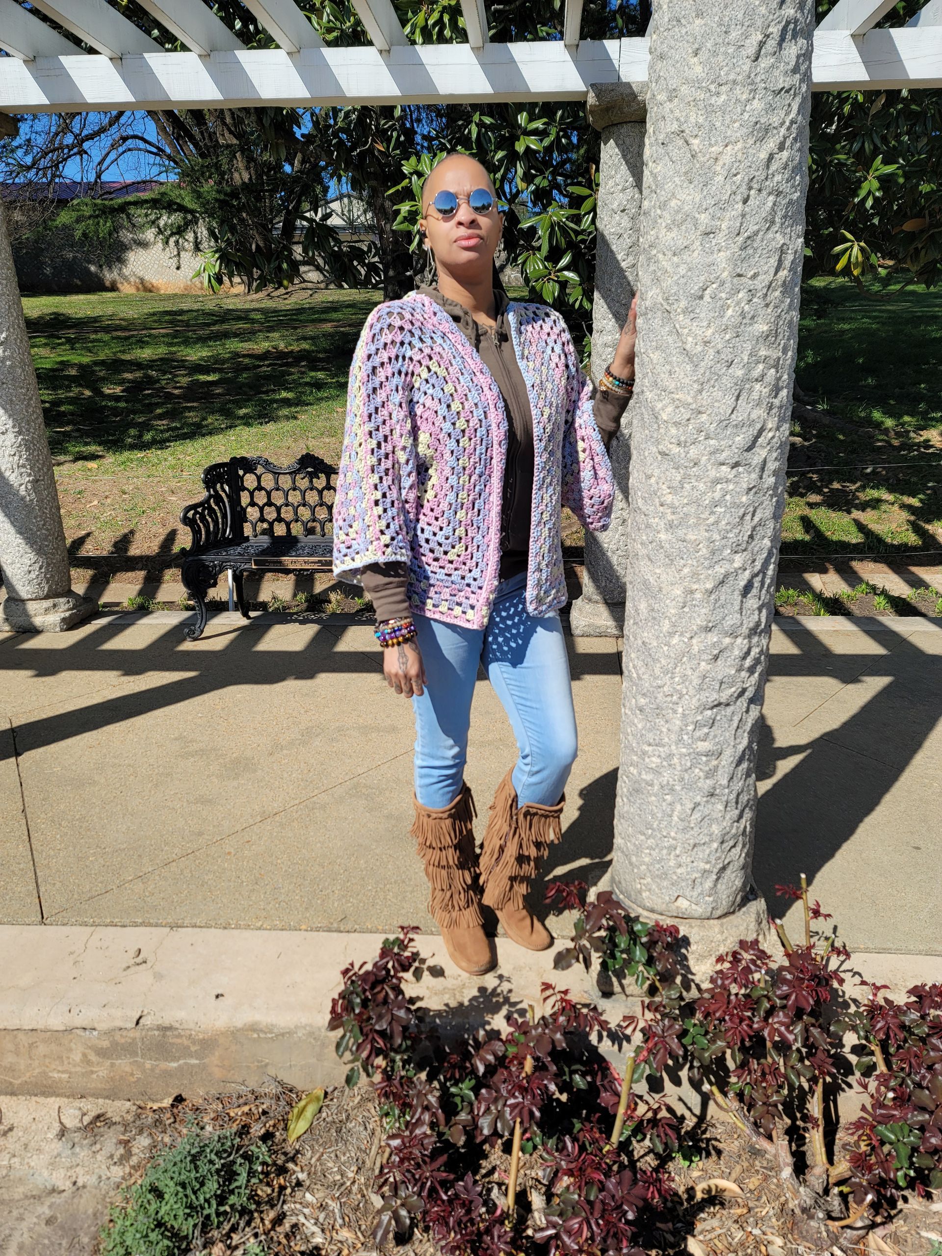 A woman is standing next to a tree in a park.