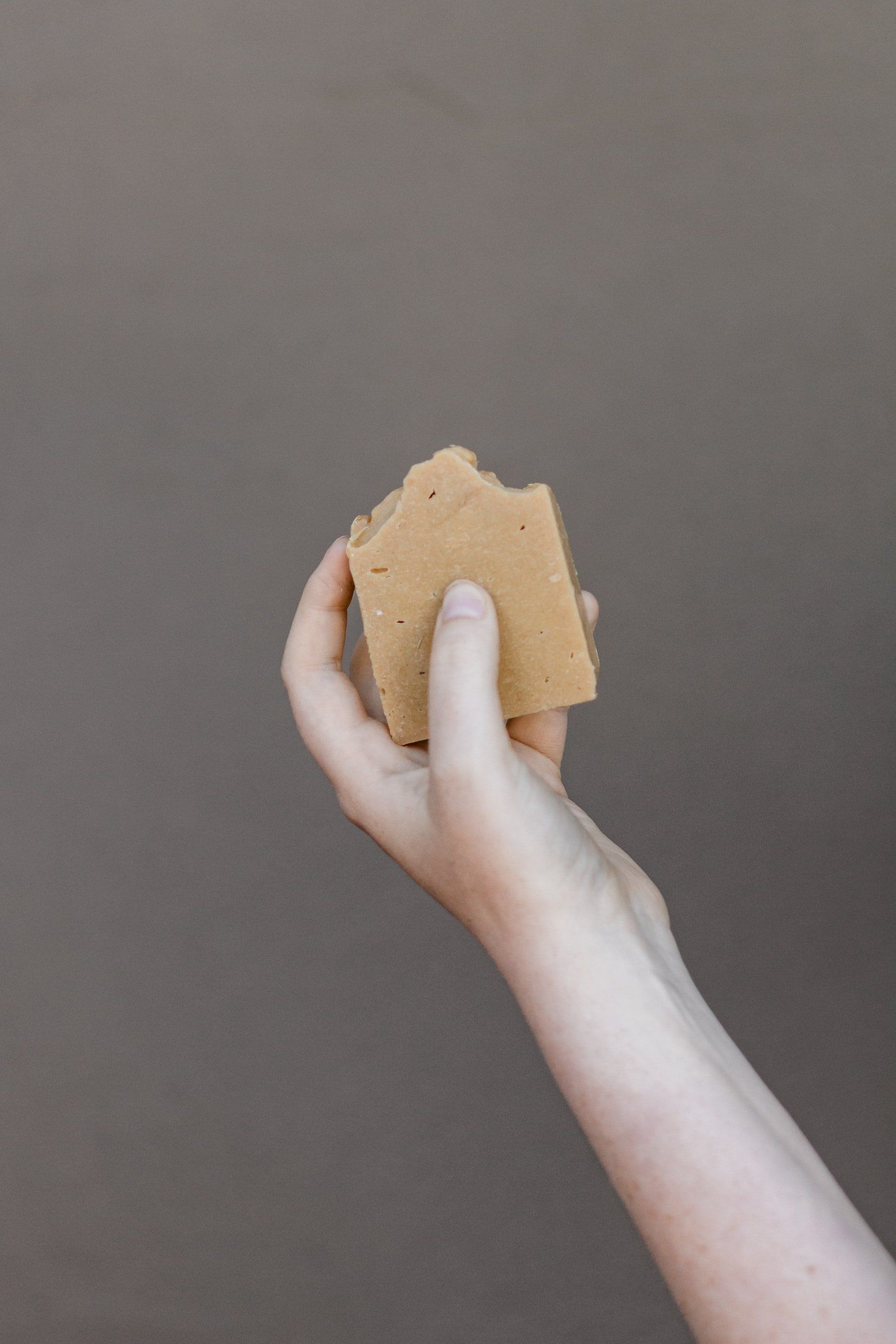 A person is holding a piece of soap in their hand.