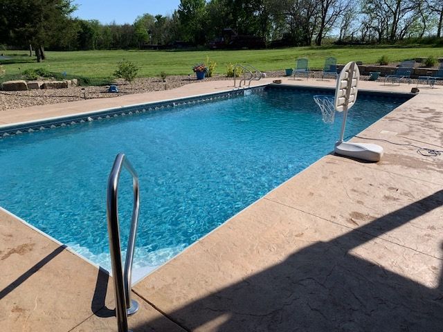 A large swimming pool with a basketball hoop in the middle