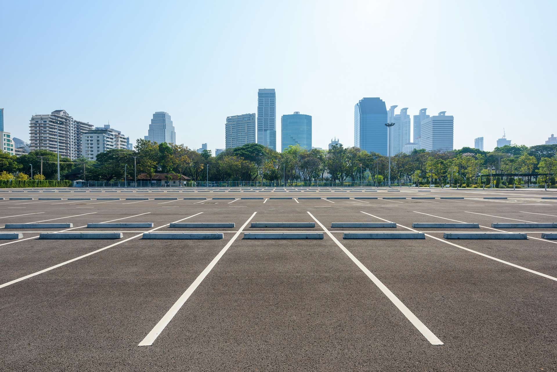 An empty parking lot with a city skyline in the background