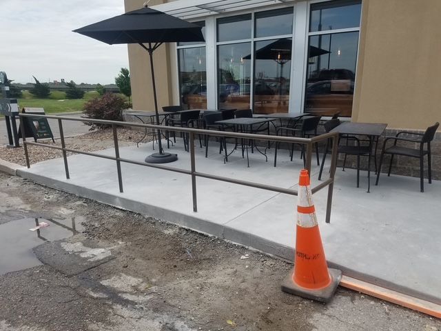 A patio with tables and chairs outside of a building