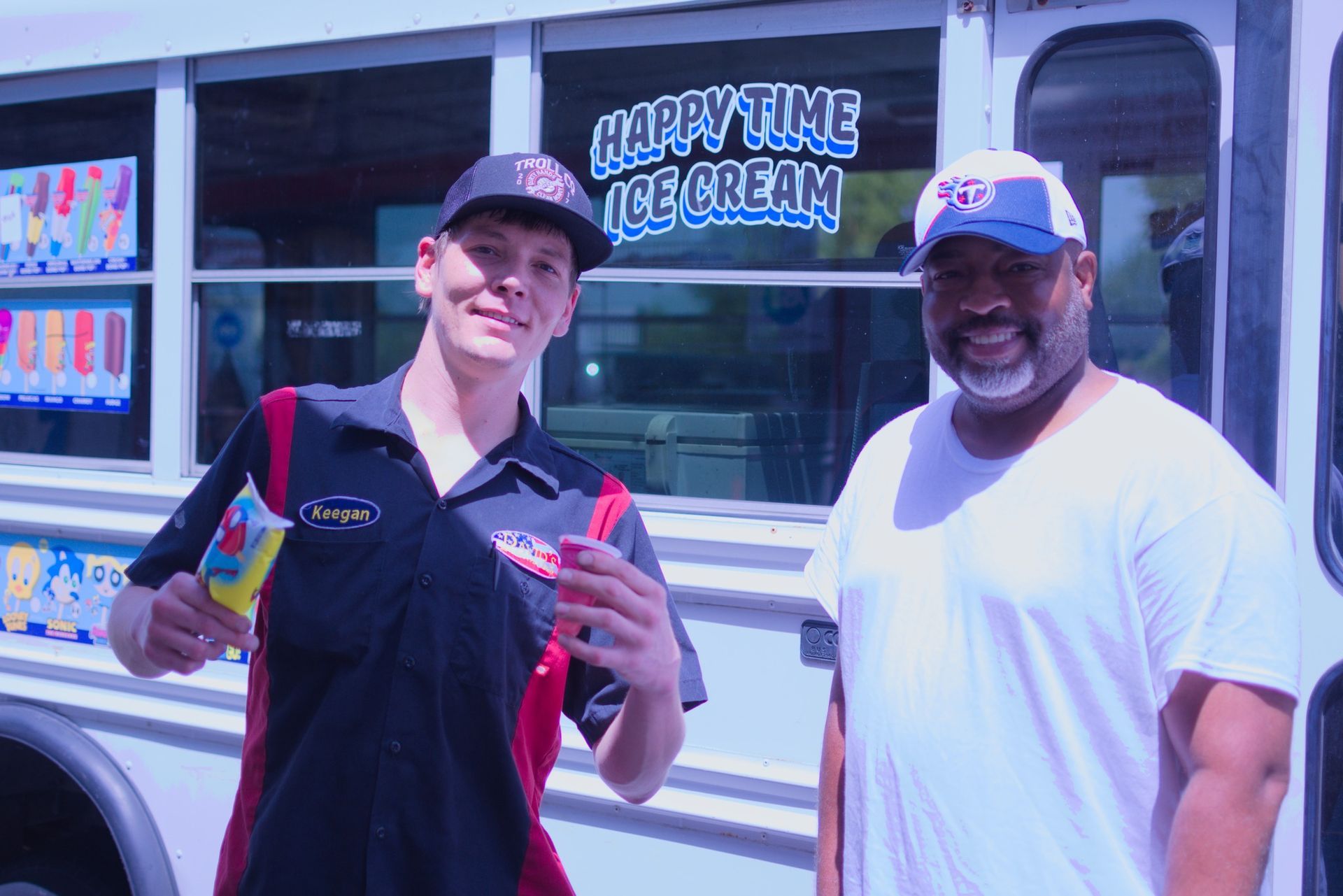 Two men are standing in front of an ice cream truck that says happy time ice cream | David's Automotive Repair