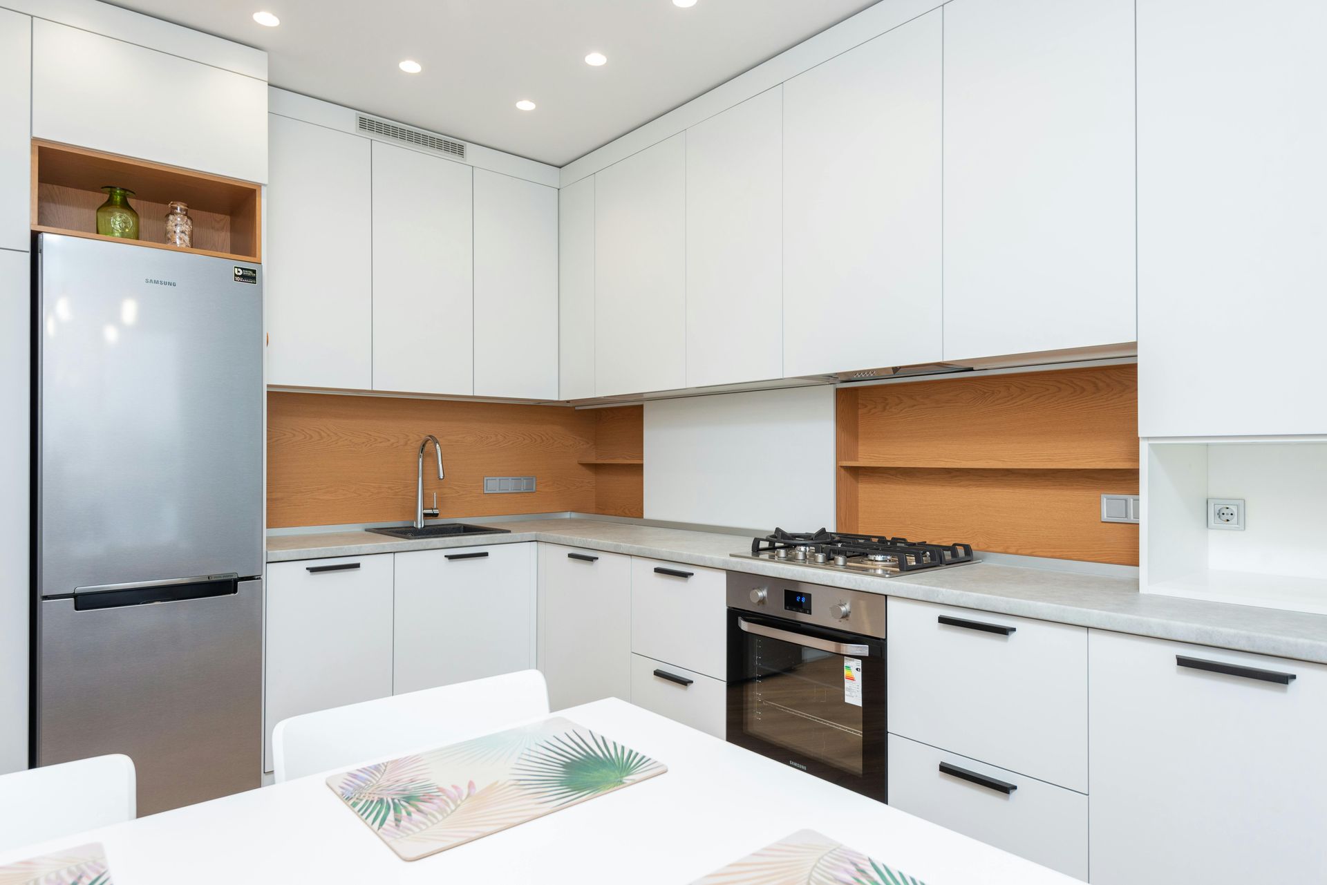 A kitchen with white cabinets and stainless steel appliances