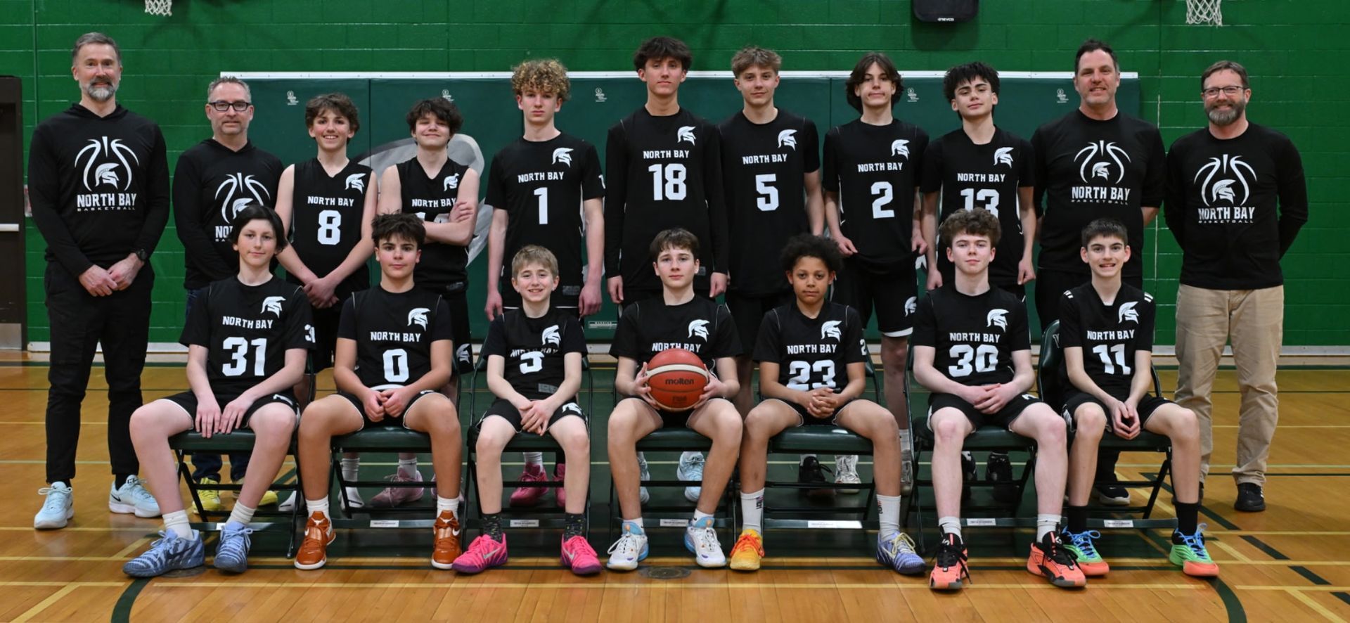 A youth basketball team, U14 Boys Champions, poses with a banner and medals.