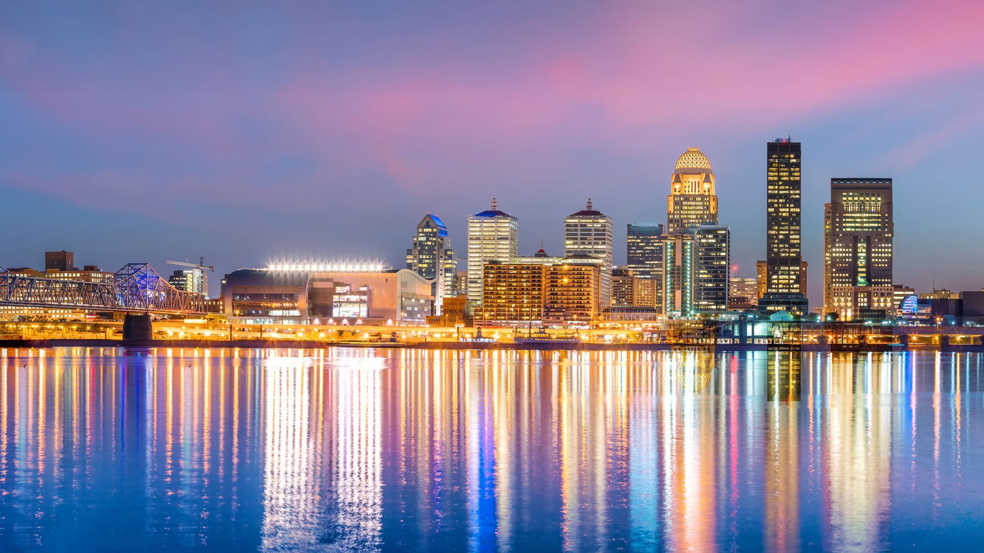 The city skyline is reflected in the water at night.