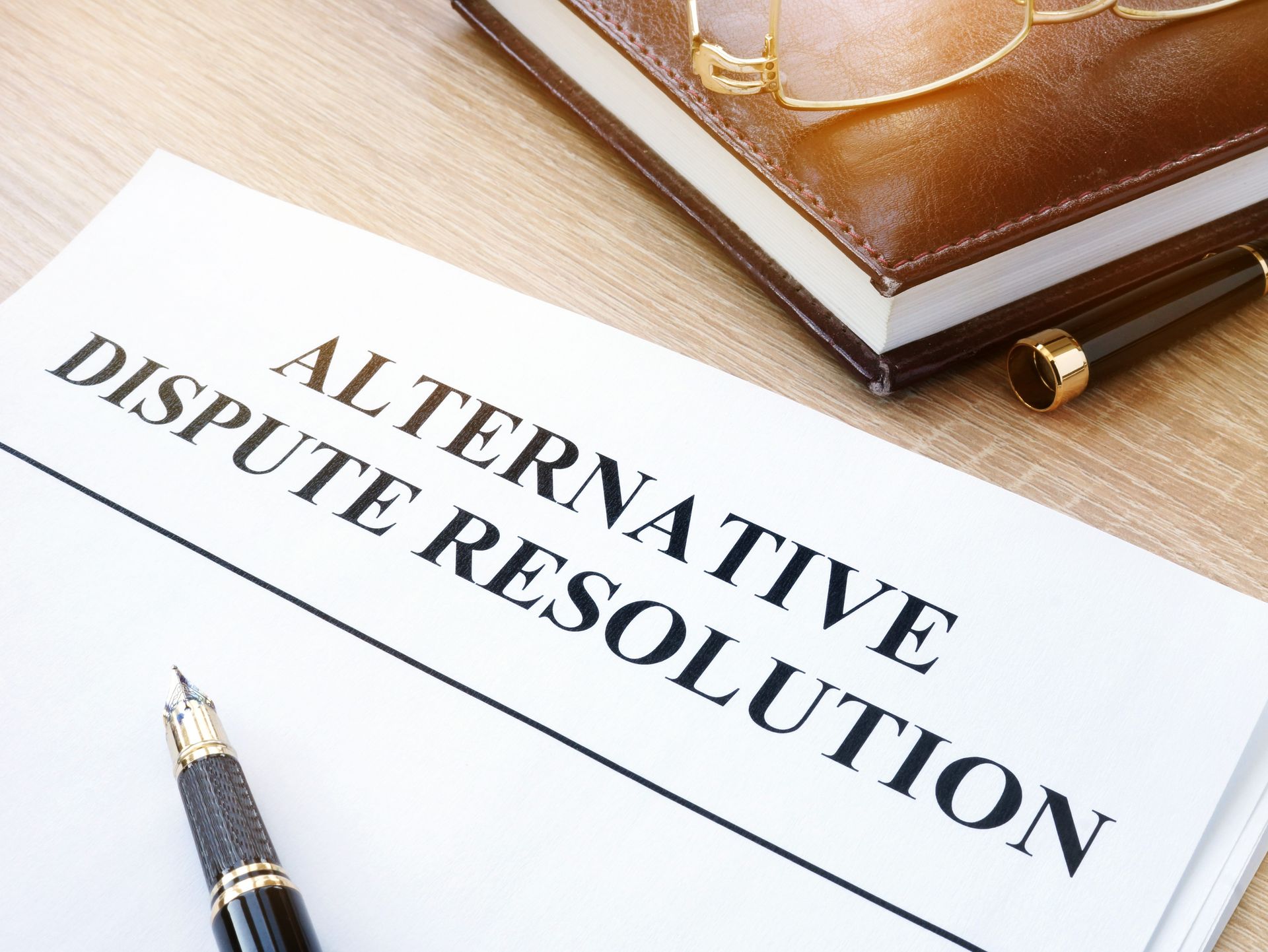 A pen is sitting on top of a piece of paper that says alternative dispute resolution.