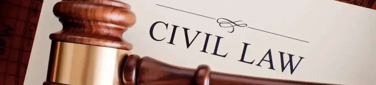 A wooden gavel is sitting on top of a piece of paper that says civil law.