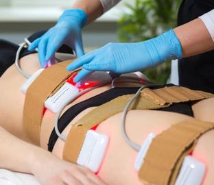 A woman is getting a laser treatment on her stomach.