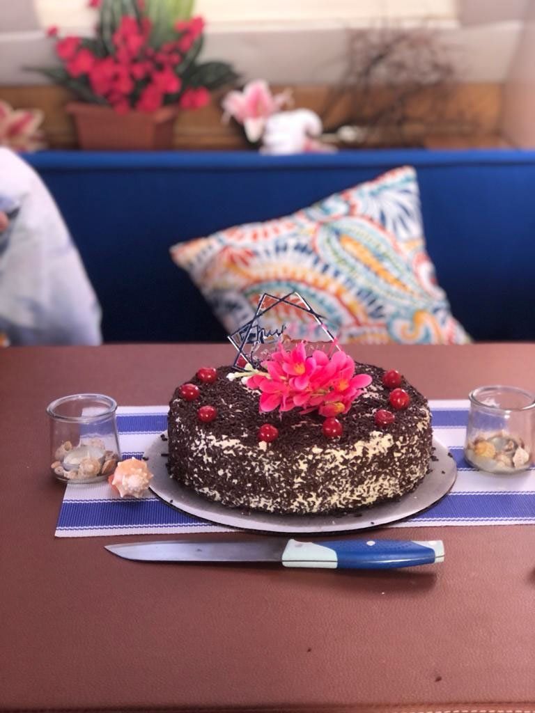 Celebration cake with white frosting on a table aboard Sailβ―Theβ―Phoenix ready to slice