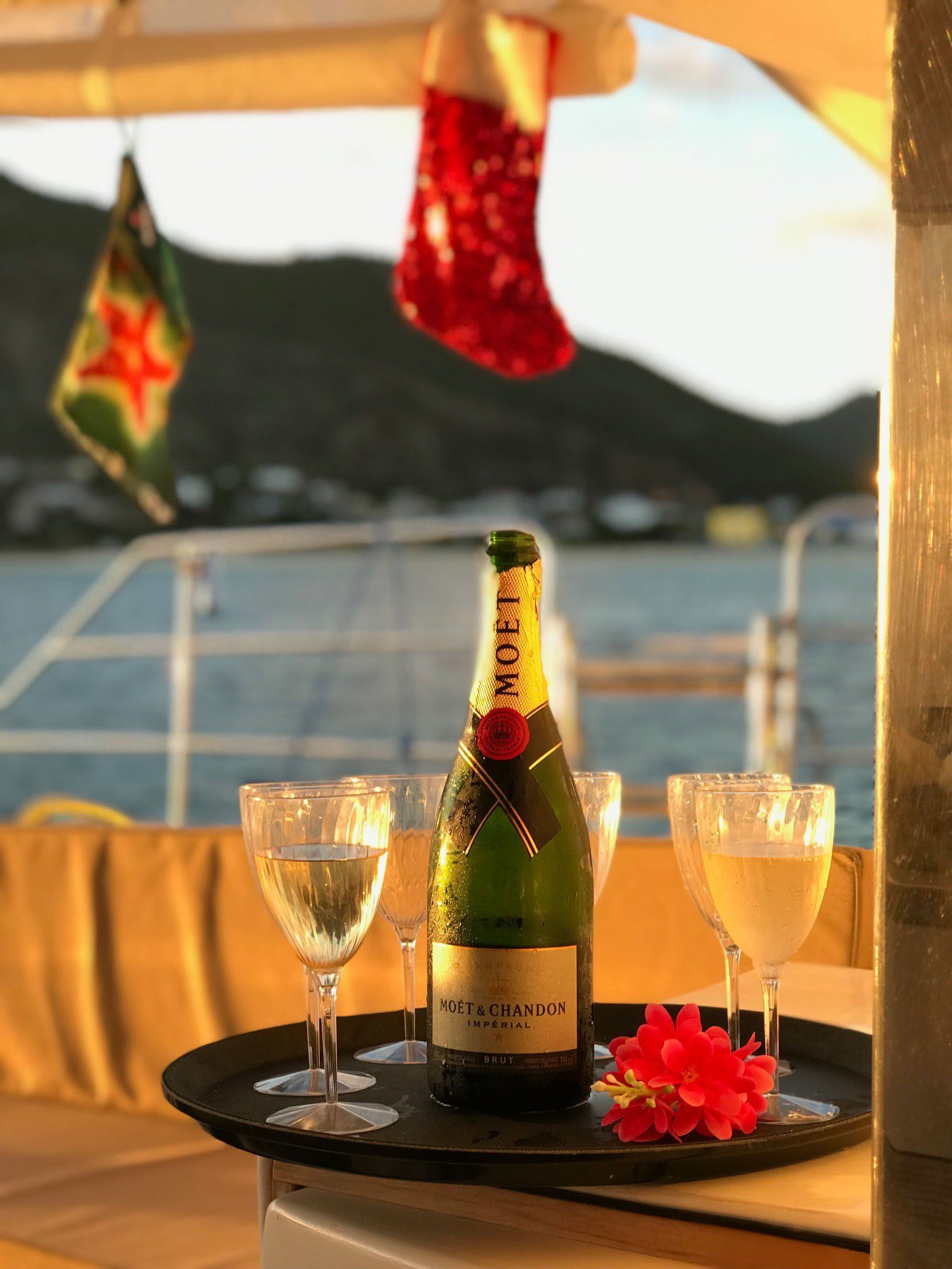 MoΓ«tβ―&β―Chandon bottle on a table aboard Sailβ―Theβ―Phoenix with filled flutes poised for a sunset toast
