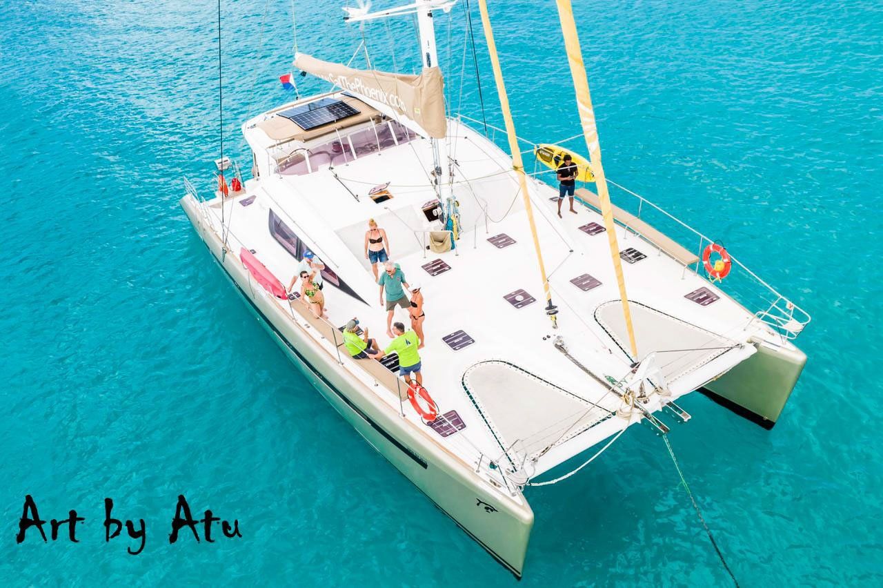Aerial drone view of Sailβ―Theβ―Phoenix anchored in crystalβclear blue waters near Sint Maarten