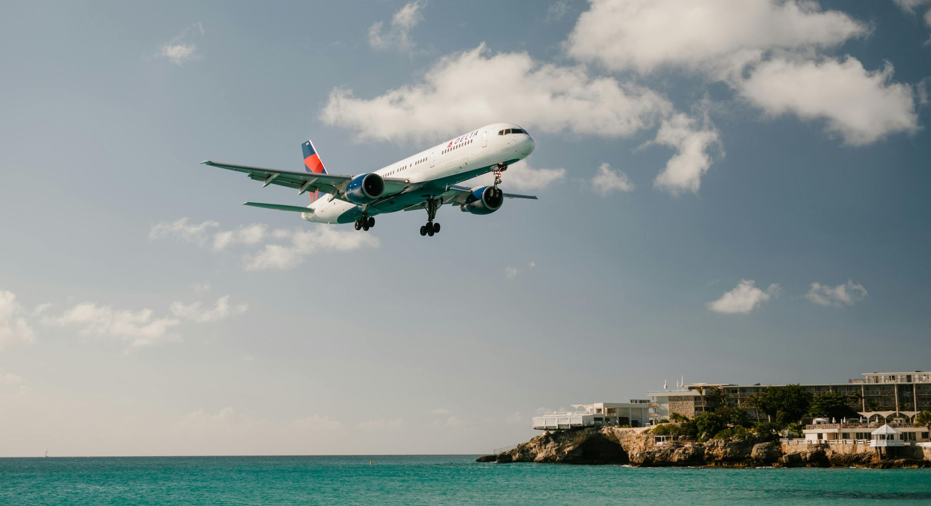 Airplane landing over Maho Beach St. Maarten as seen from luxury catamaran Sail the Phoenix