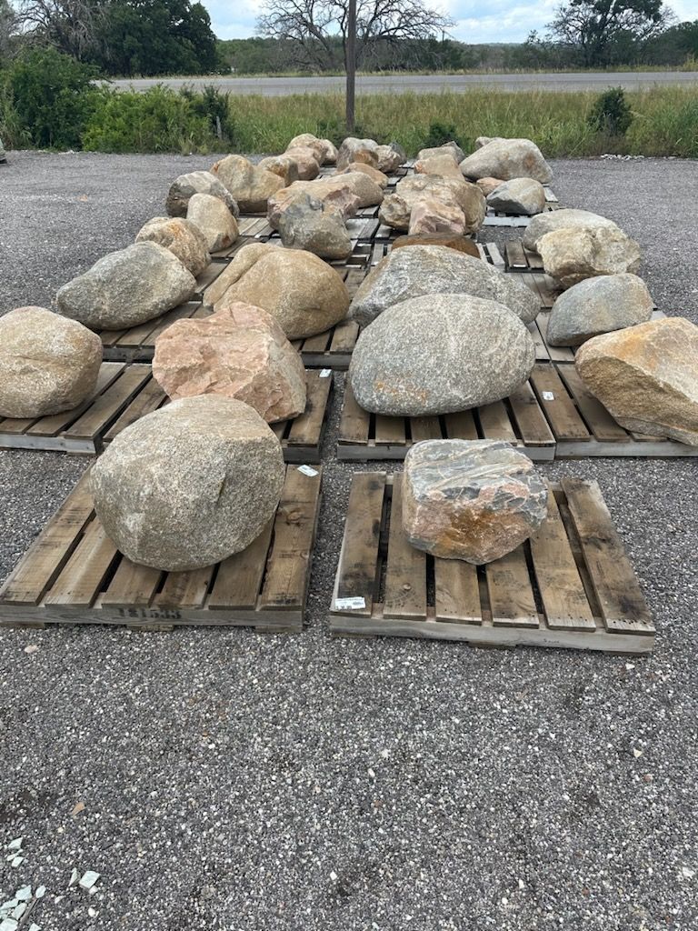 A pile of rocks sitting on top of wooden pallets on the ground.
