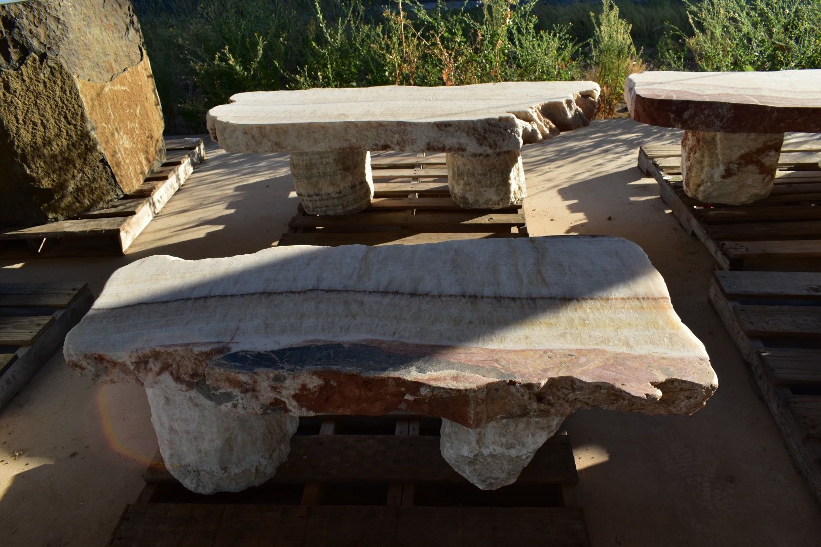 A group of stone benches sitting on top of wooden pallets