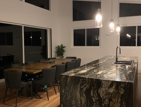 A Kitchen With a Large Island and a Dining Table — Rob Ward Electrical Services in West Ballina, NSW
