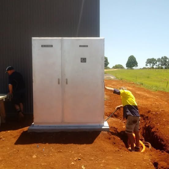 A Man in a Yellow Shirt is Digging in the Dirt — Rob Ward Electrical Services in West Ballina, NSW