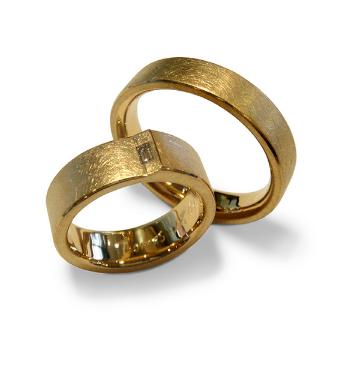 Ein Paar goldene Eheringe auf weißem Hintergrund
