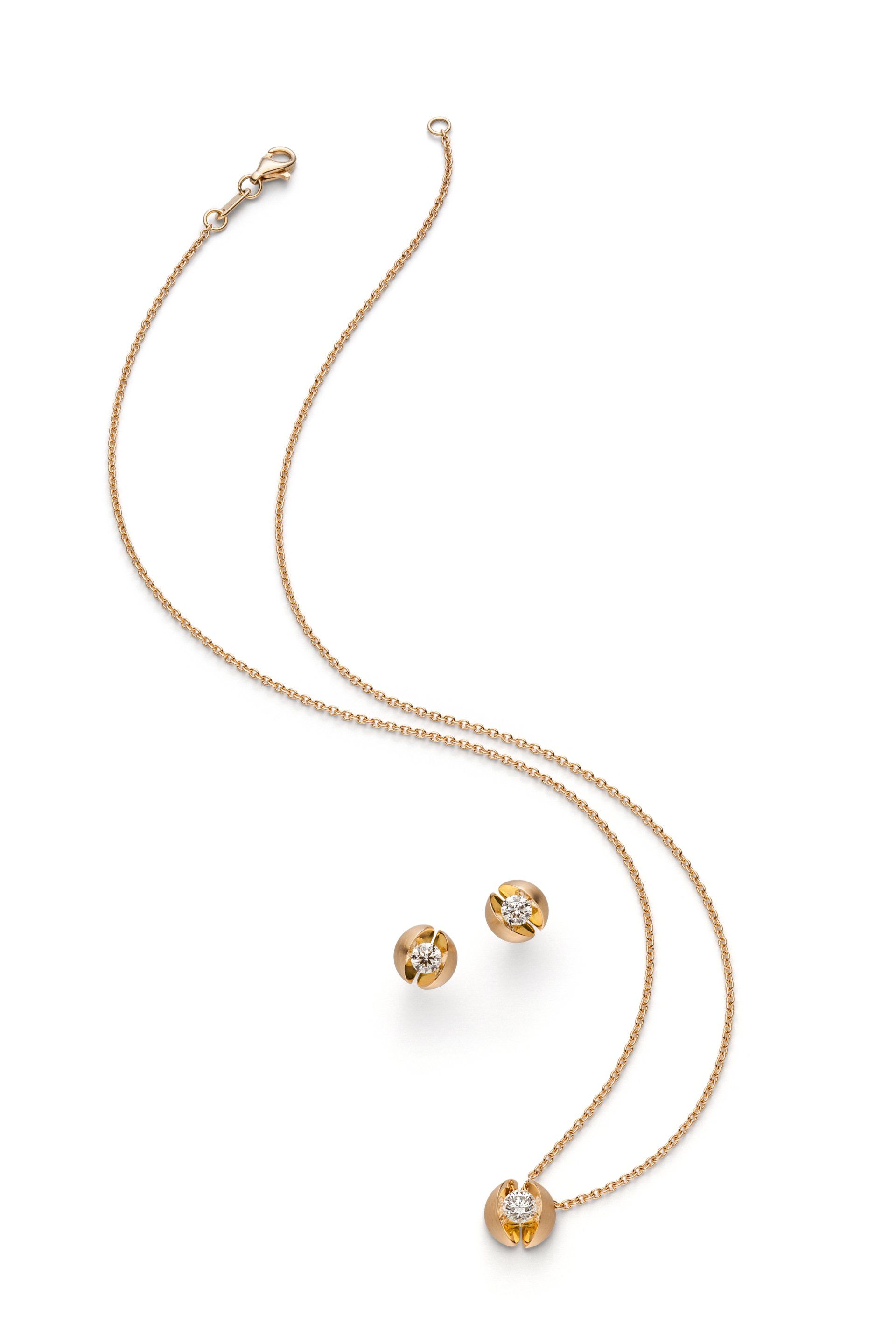 Eine Halskette und Ohrringe auf weißem Hintergrund