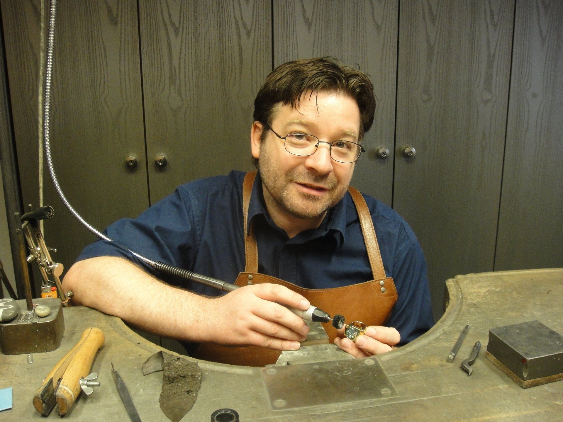 Ein Mann in einer Schürze arbeitet an einem Stück Metall