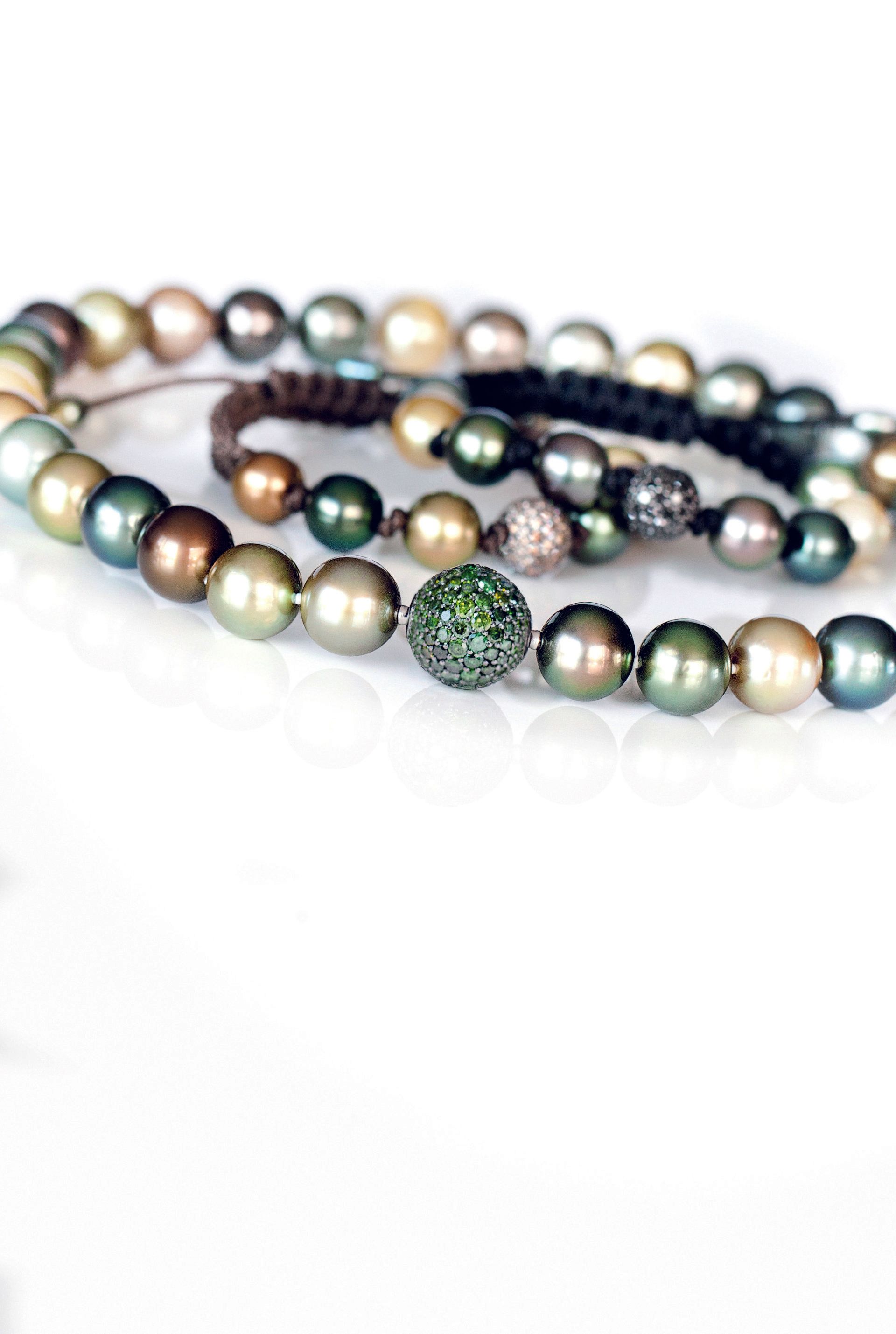 Eine Nahaufnahme eines Armbands mit grünen Perlen auf einer weißen Oberfläche.