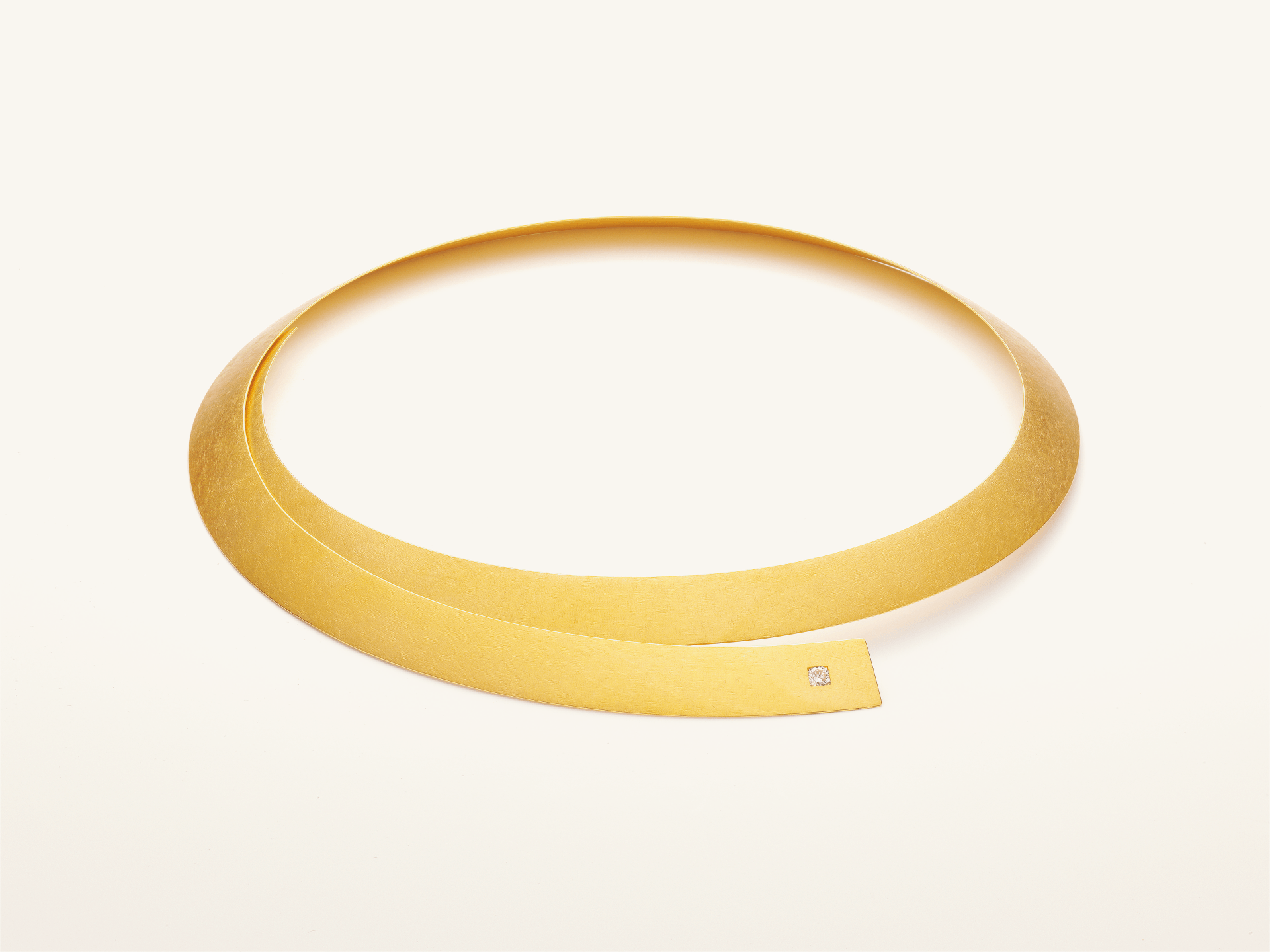 Eine silberne Halskette mit einem Anhänger, der wie eine Zahl 6 aussieht