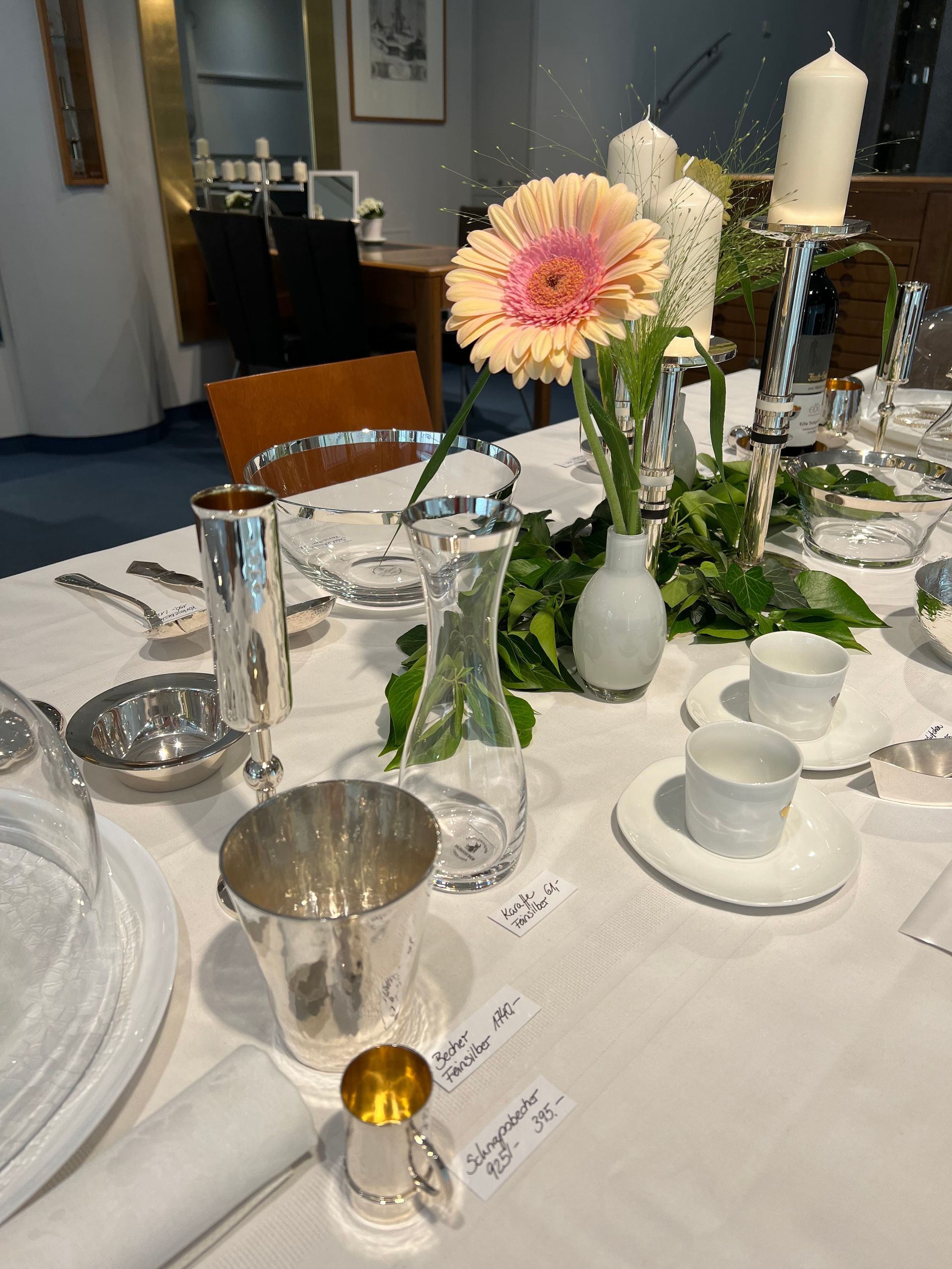 Ein Tisch mit einer Vase mit Blumen und Kerzen darauf