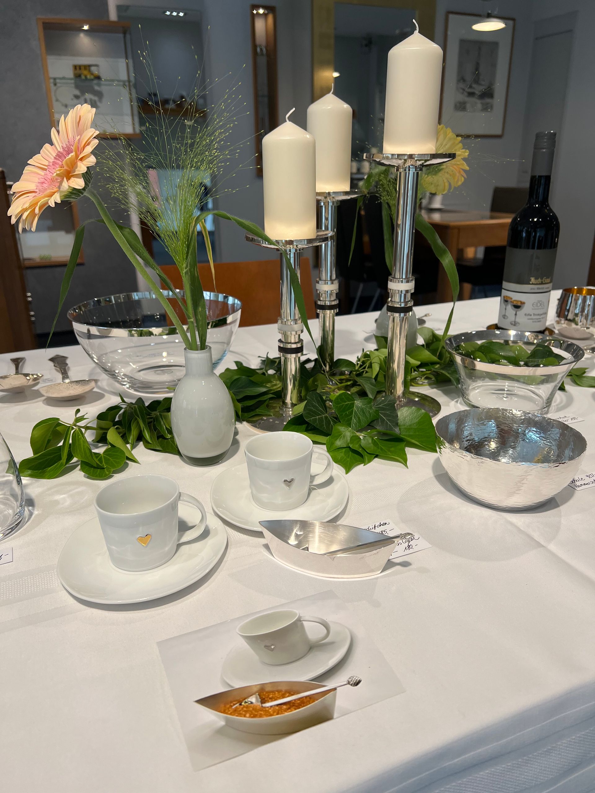 Ein Tisch mit Kerzen, Tassen und Untertassen darauf