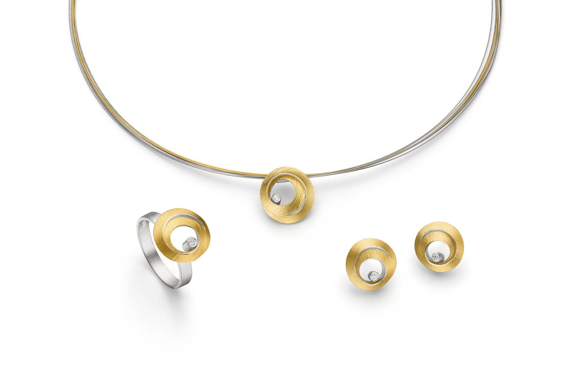 Eine Halskette, ein Ring und Ohrringe befinden sich auf einem weißen Hintergrund.