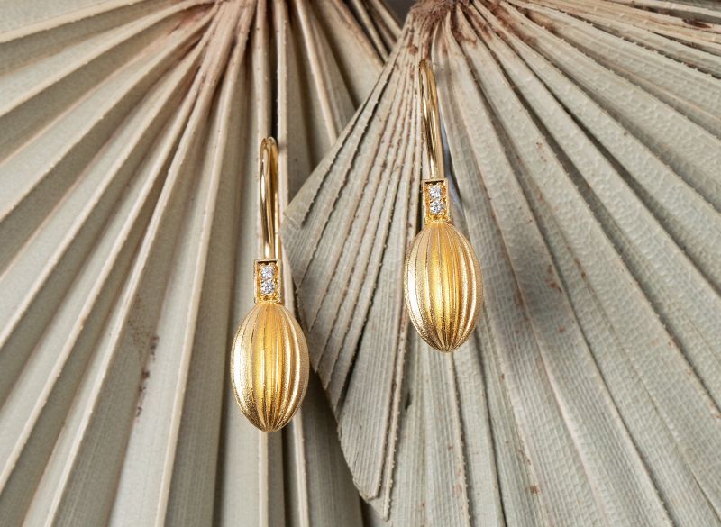 Eine Frau trägt eine Halskette, einen Ring, ein Armband und Ohrringe.