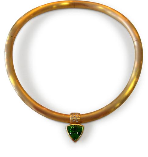 Eine goldene Halskette mit einem grünen Steinanhänger