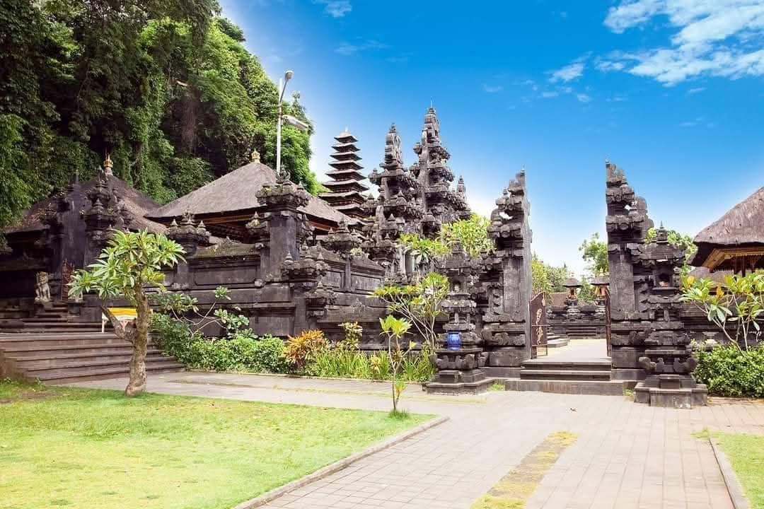 Stone temple complex with traditional Balinese architecture under a blue sky.