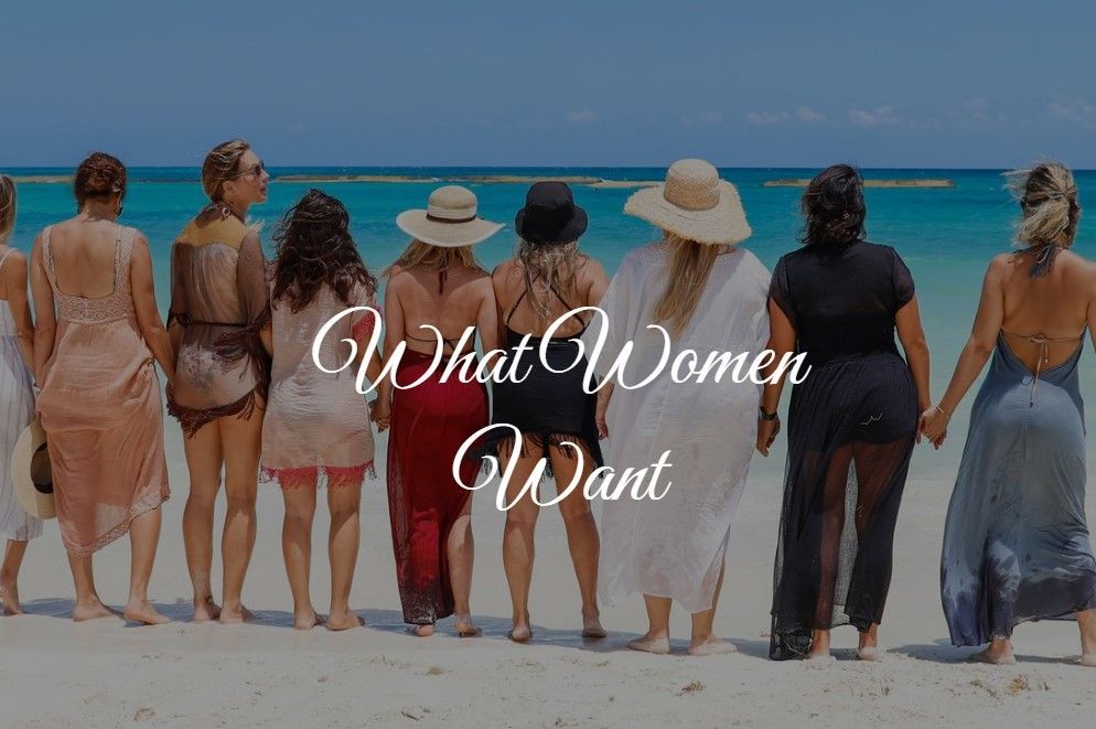 Women holding hands on beach, facing ocean. Text overlays: What Women Want.