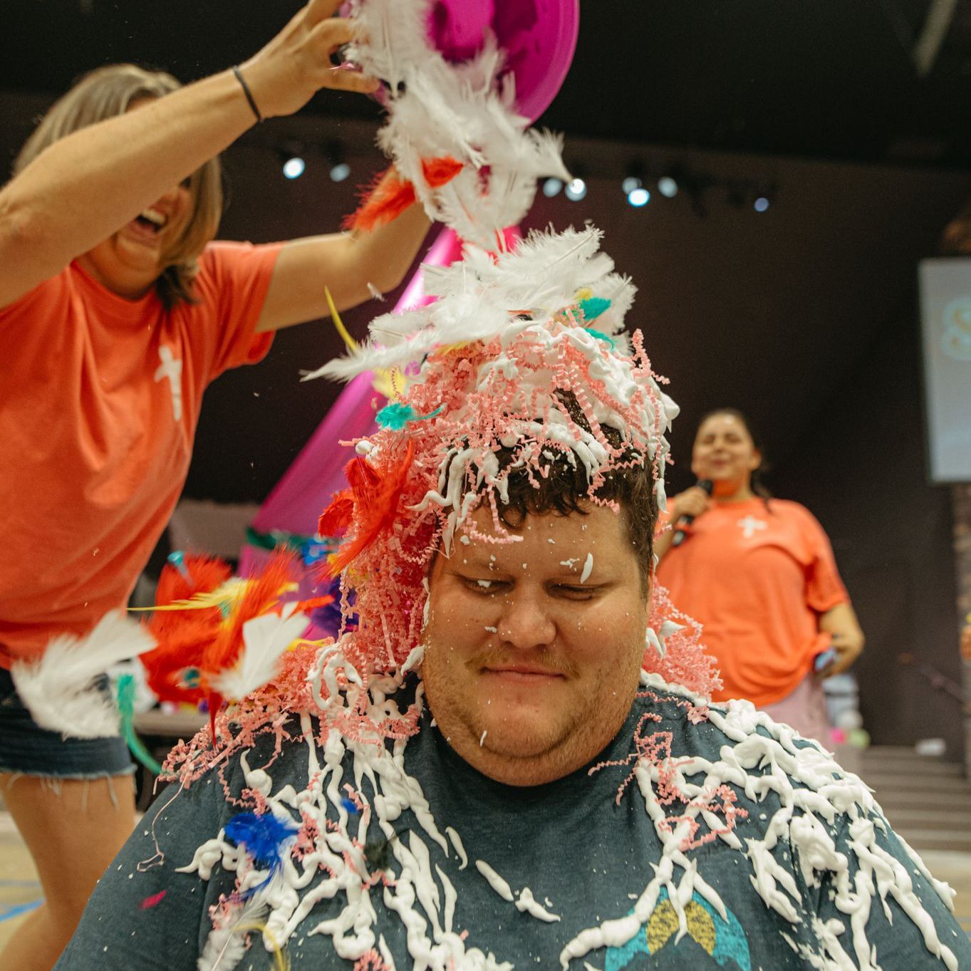 A woman in a purple shirt is covered in foam