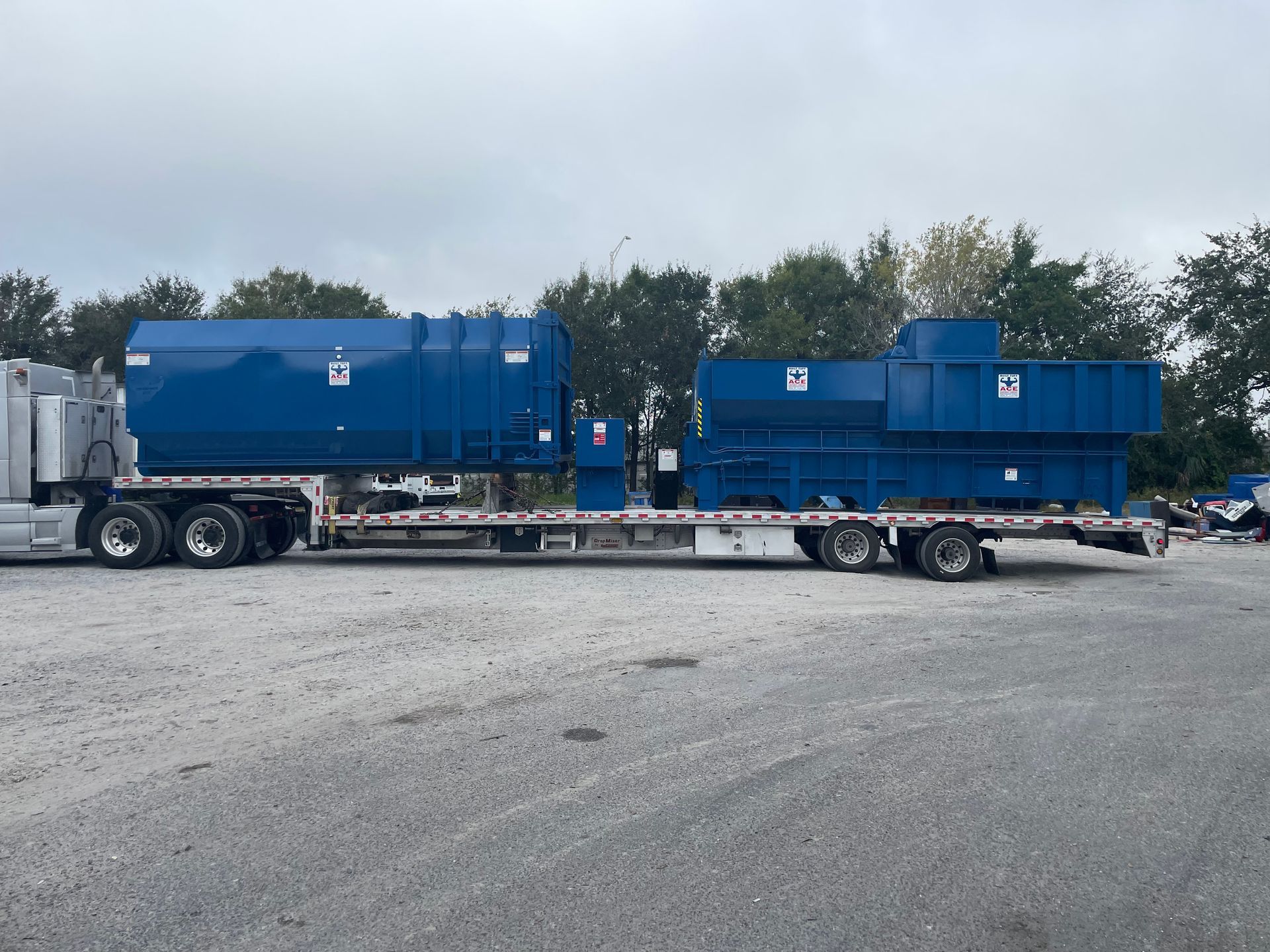 A semi truck is carrying a large blue tank on a flatbed trailer.