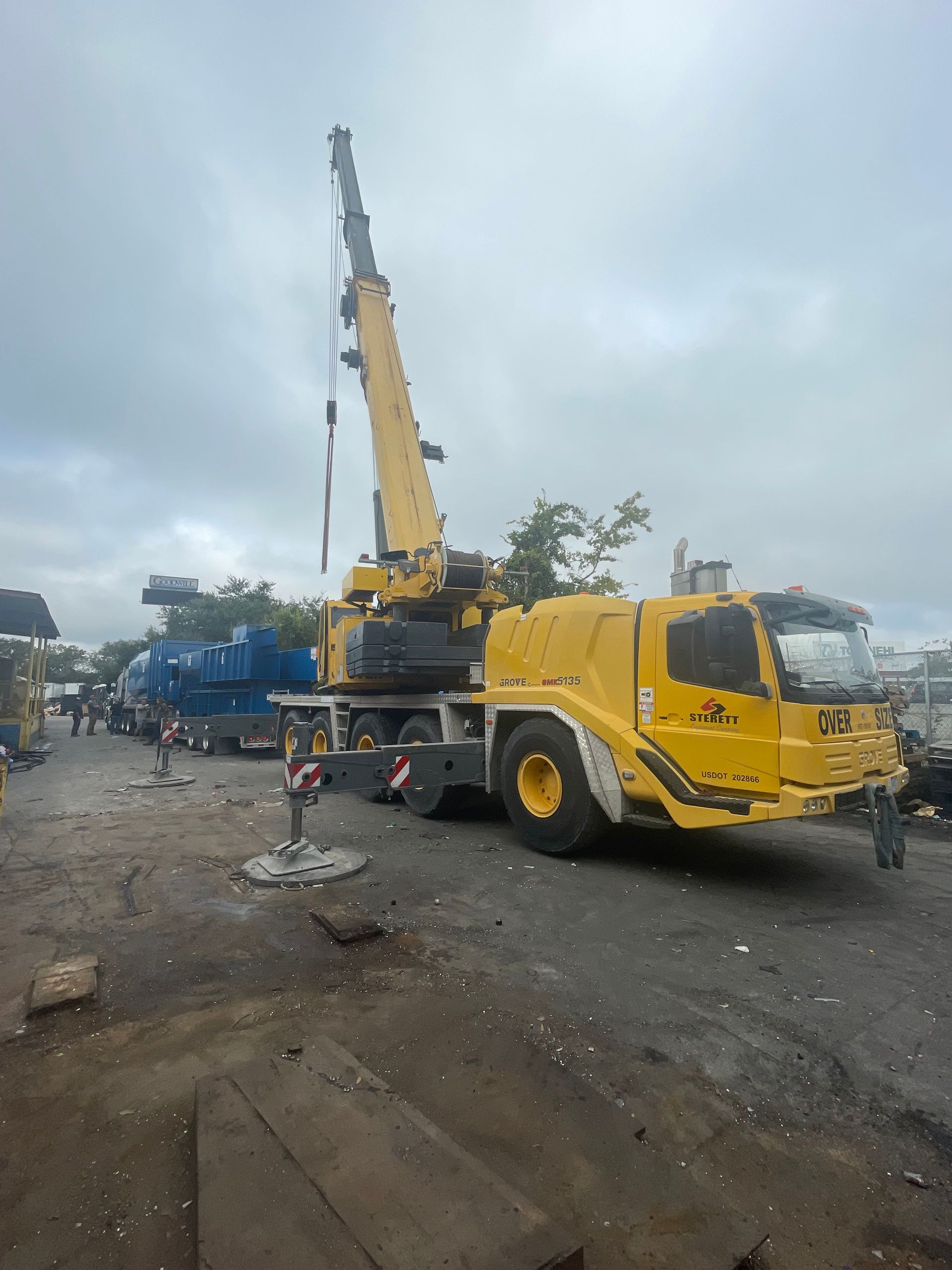 A large yellow crane is parked in a parking lot.