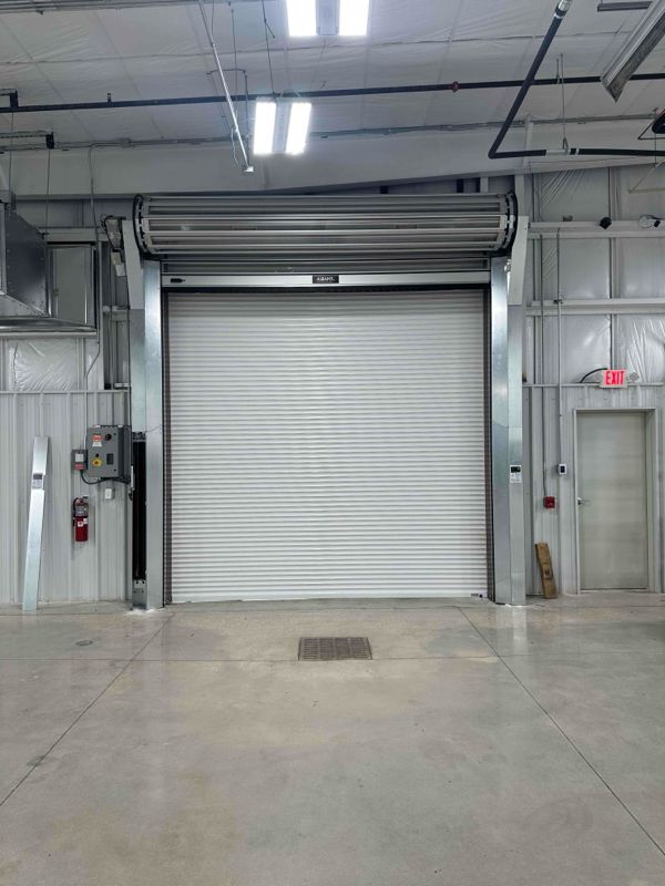 An empty warehouse with a large white garage door.