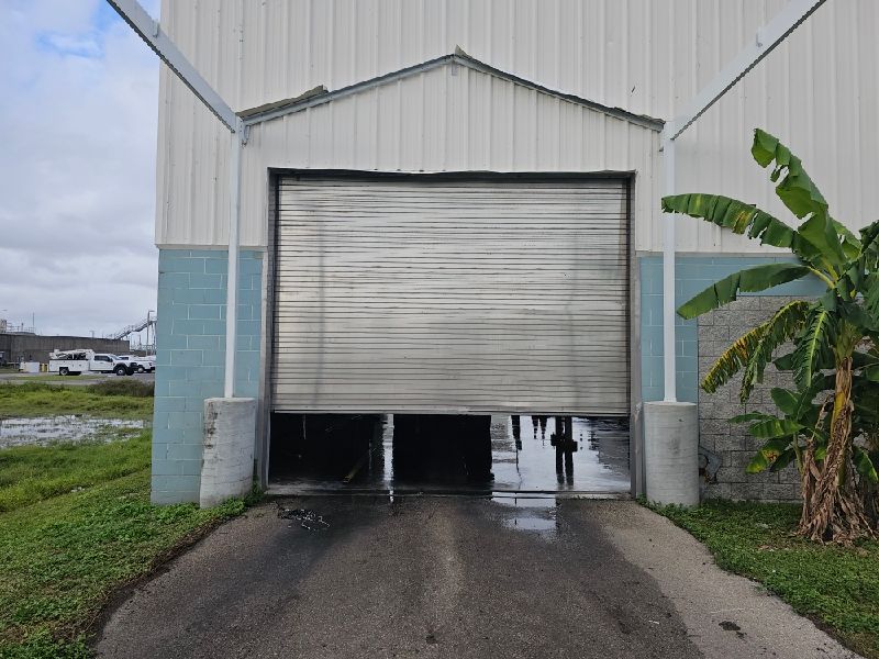 A large garage door is open in front of a building.