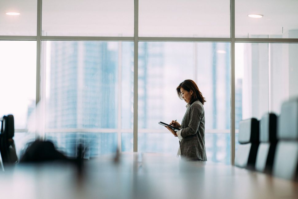 woman writing in a boardroom