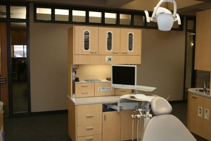 A dental office with a chair and a computer