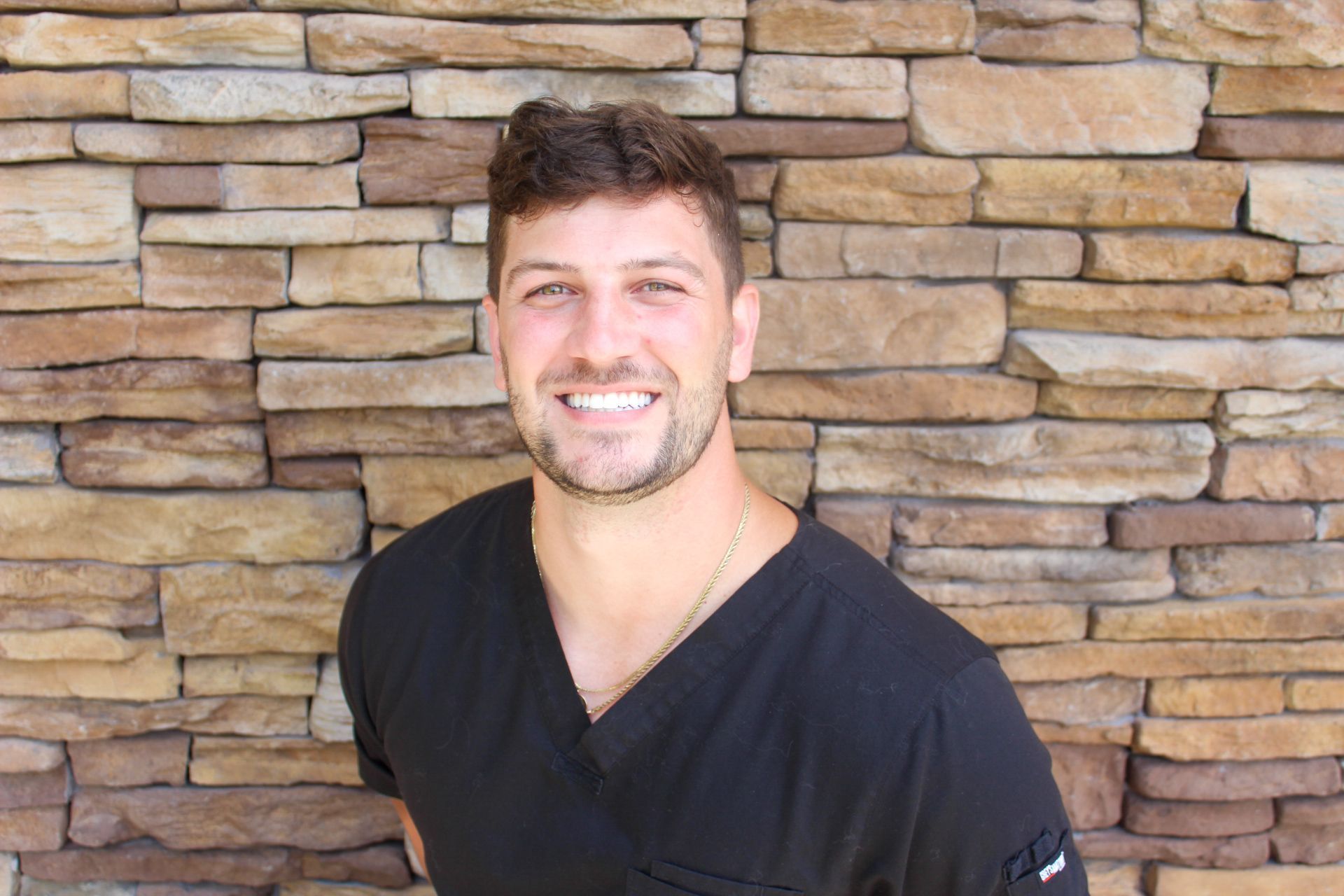A man smiling and wearing dentist's uniform. A family dentist in Lee's Summit, MO.