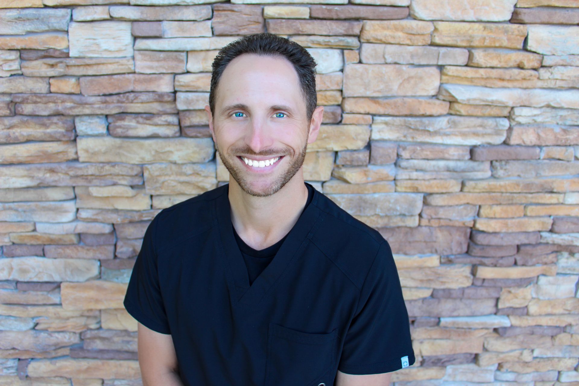 A man with a beard is smiling in a circle. The top dentist in Lee's Summit, MO