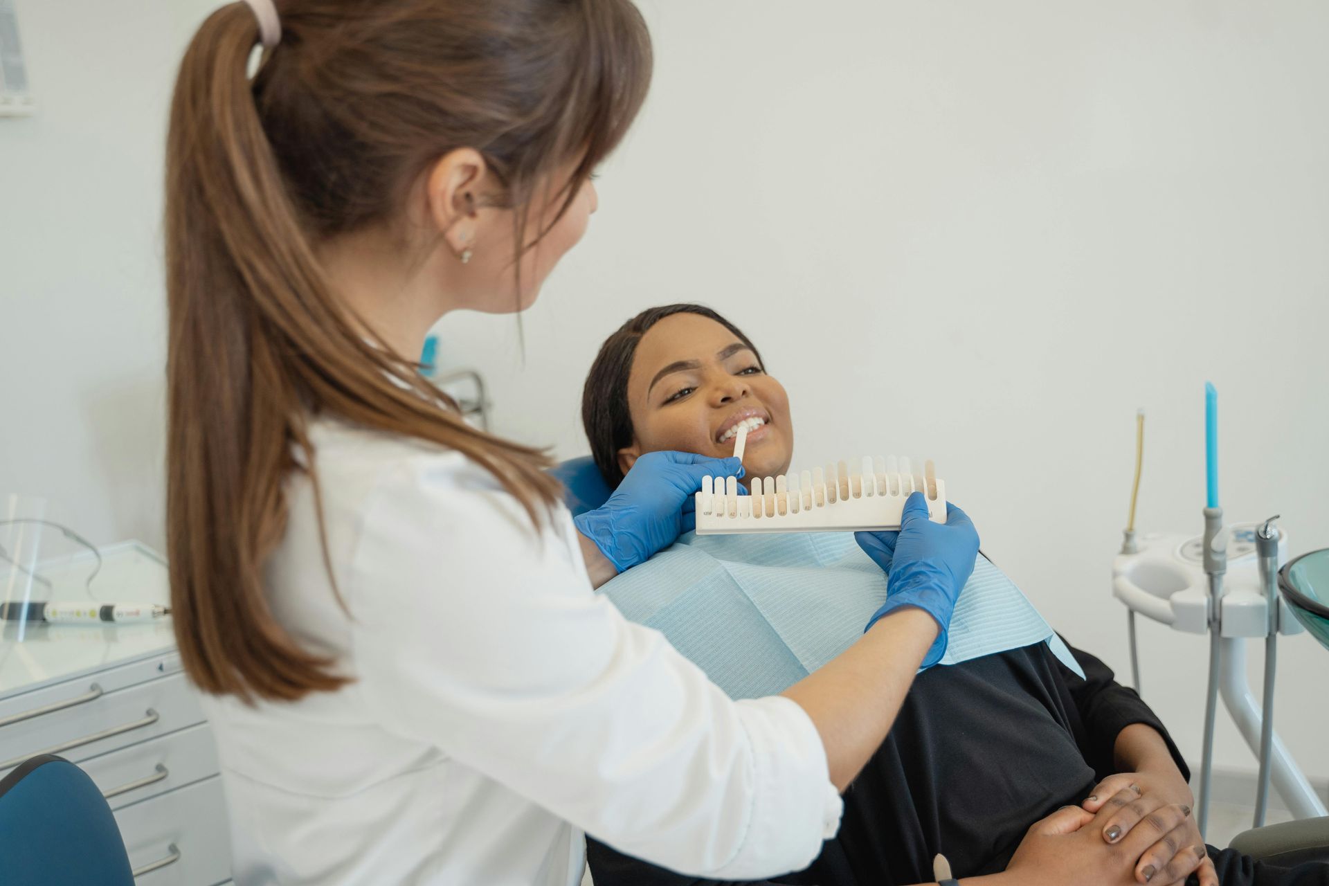 A dentist is examining a patient 's teeth in a dental office.