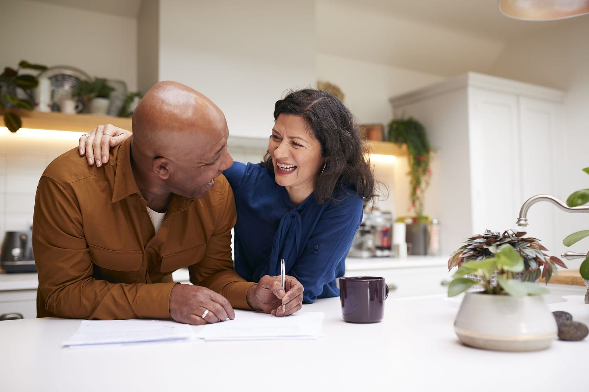 Smiling Mature Couple Signing Paperwork